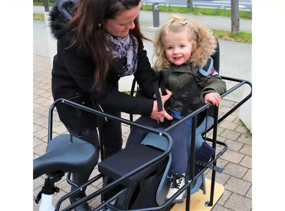 Petite fille contente d'être installée sur un siège enfant