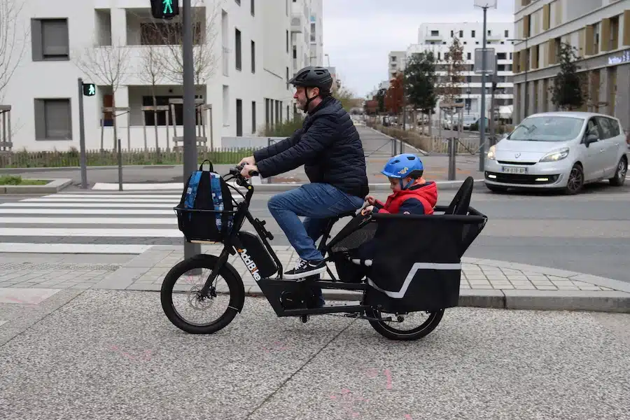 Lastenfahrrad Kinder: Kinder fahren mit ihrem Vater auf einem Longtail