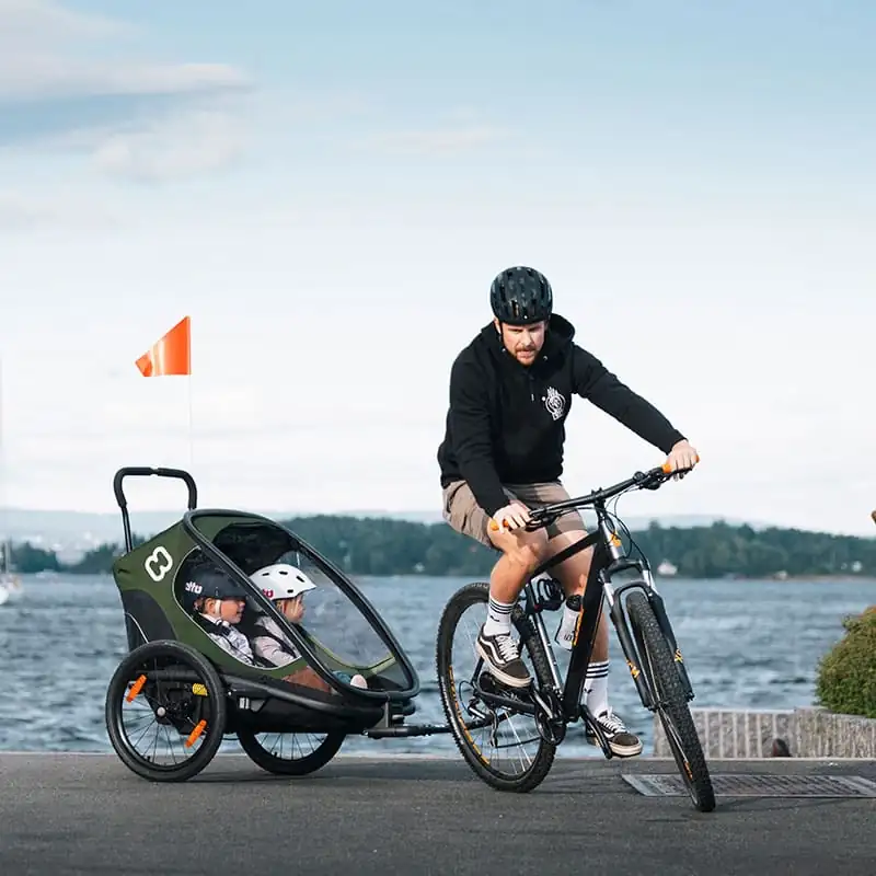 Vélo avec remorque devant pour transporter deux enfants au bord de la mer