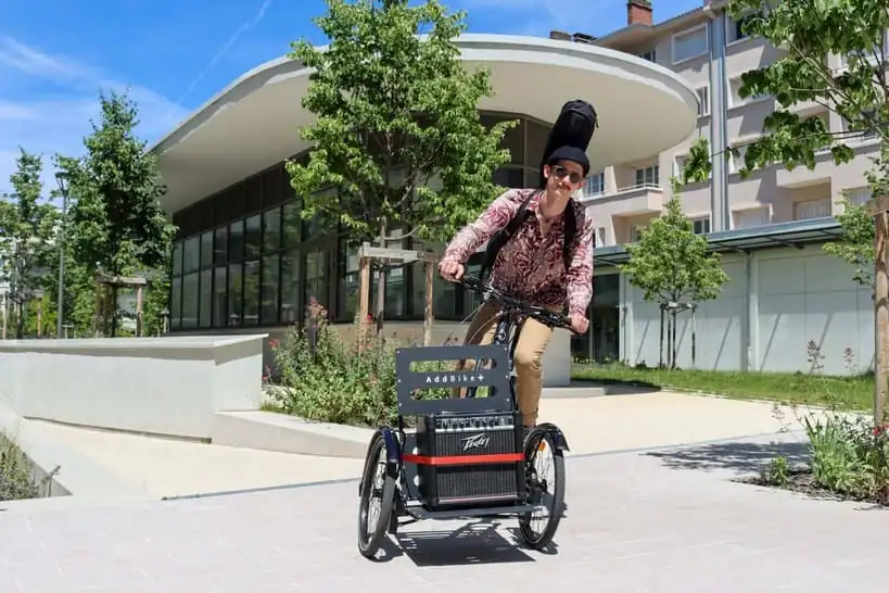 Vélo avec remorque devant qui porte des instruments de musique